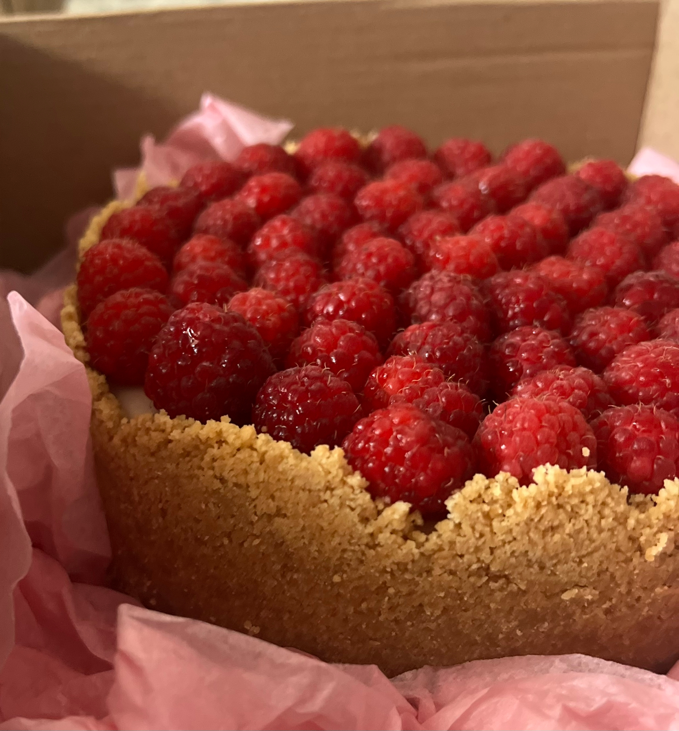 Целый чизкейк с малиной в розовой бумаге в фирменной коробке — VIKICAKES